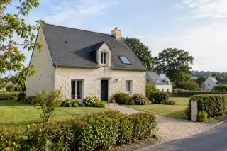 Maison individuelle au Longeron avec jardin, haie, allée et maisons voisines dans un quartier résidentiel calme, lumière du matin, arbres bocagers en arrière-plan.